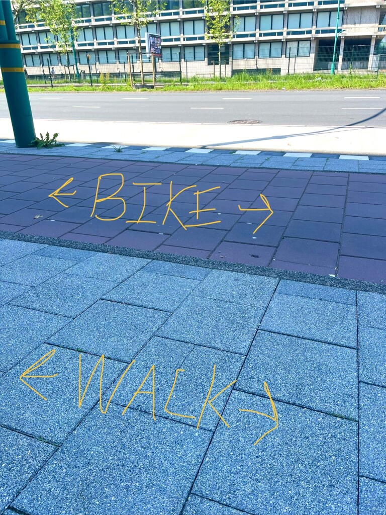 Photo of a red bike path and gray walk path side by sure, with labels 
